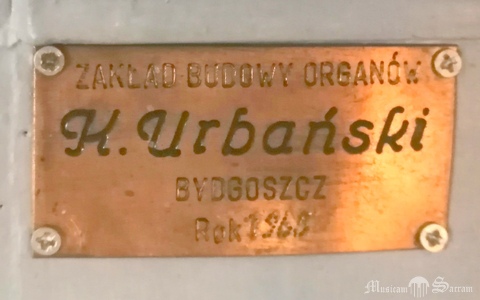Tabliczka budowniczego na szafie organowej