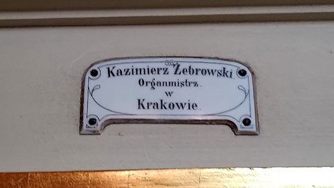 Tabliczka budowniczego na szafie organowej