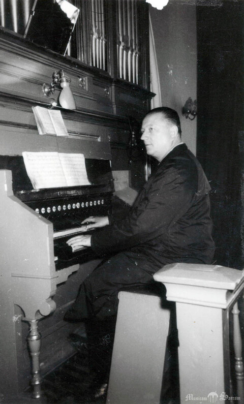 Archiwalne zdjęcie stołu gry z lat 60. XX w., przy którym siedzi organista kościoła Stanisław Dudek